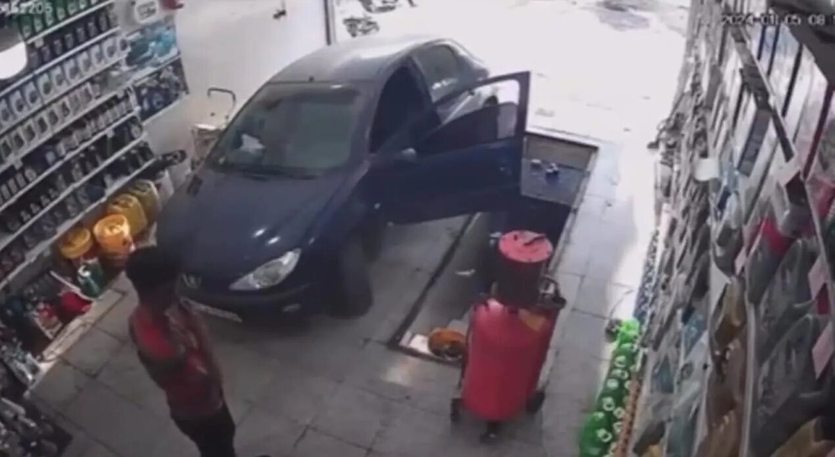 تصاویر حرکات عجیب دختر جوان در یک تعمیرگاه تهران | از سقوط دختر به چاله تعویض روغن تا فرو رفتن در سطل روغن! | ماشین را هم در چاله انداخت!